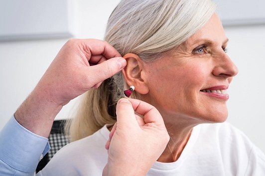 Eine Seniorin erhält ein modernes Hörgerät zur Verbesserung ihres Hörvermögens.